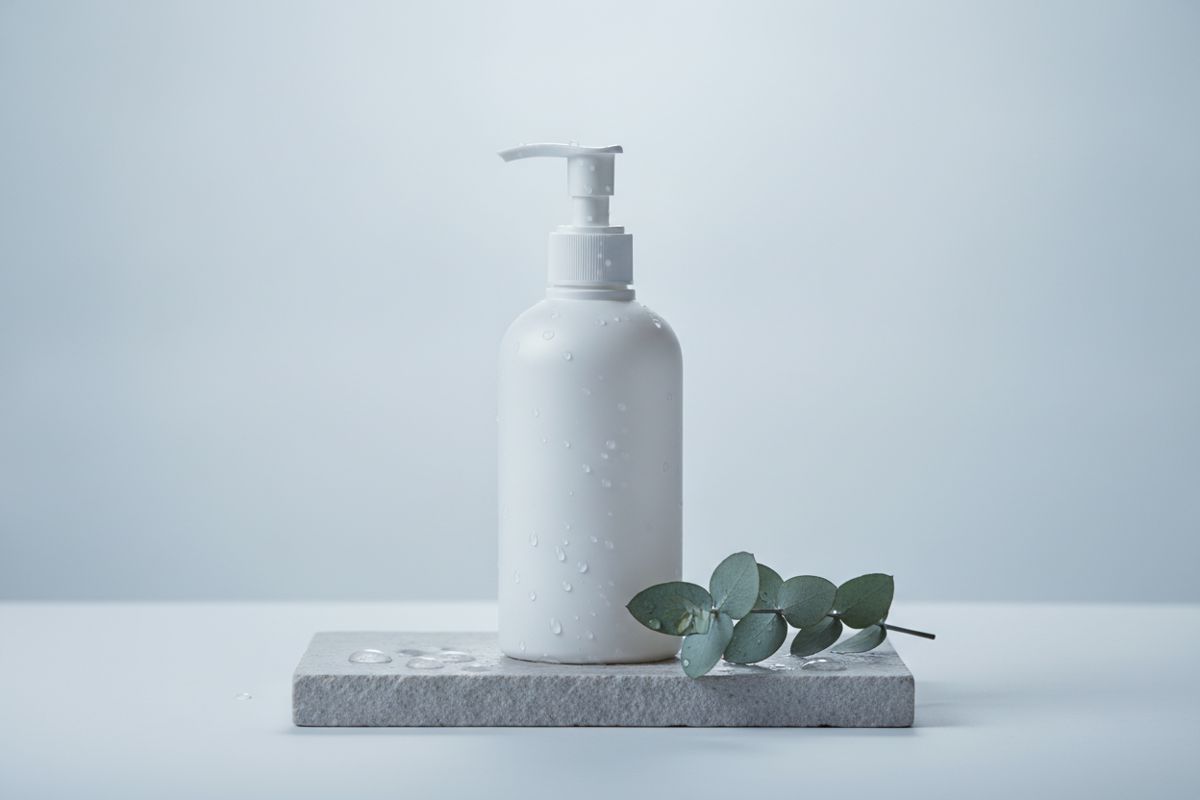 An unlabelled pump bottle on pale stone